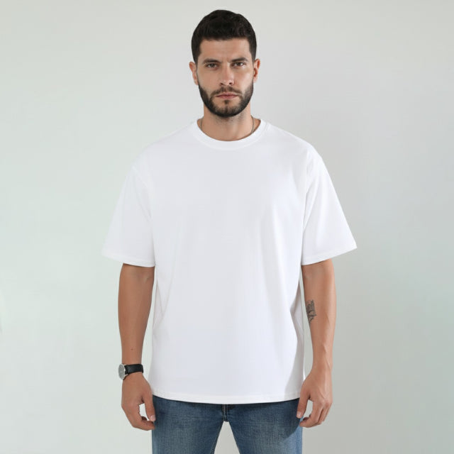 Man wearing a plain white t-shirt against a light gray background